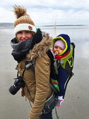 Côte d’Opale, maman voyageuse avec son enfant dans un porte bébé de randonnée